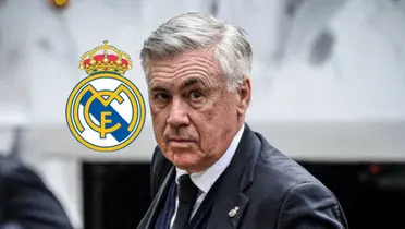 Carlo Ancelotti looks at the camera while wearing a suit and the Real Madrid logo is next to him.