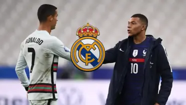 Cristiano Ronaldo and Kylian Mbappé shake hands while the Real Madrid badge is in the middle.