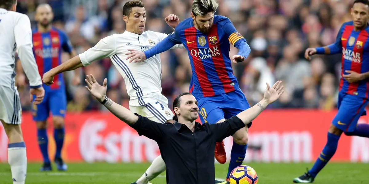 Cristiano Ronaldo and Lionel Messi contest for the ball at the same time and Zlatan Ibrahimovic extends his arms out with a smile.