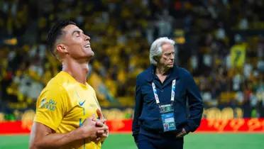 Cristiano Ronaldo does the sleep celebration wearing an Al Nassr shirt while Jorge Jesus looks serious.