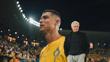 Cristiano Ronaldo looking at the crowd with an Al Nassr shirt and Jose Mourinho looking to his left with a black sweater and coat.