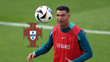Cristiano Ronaldo looks at the ball while wearing the Portugal training kit; the Portugal national team badge is next to him.