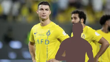 Cristiano Ronaldo puts his hand on his hips while wearing the Al Nassr jersey and a mystery player is below him.