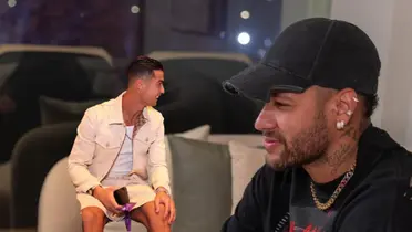 Cristiano Ronaldo smiles wearing a Gucci outfit while Neymar smiles wearing a hat.