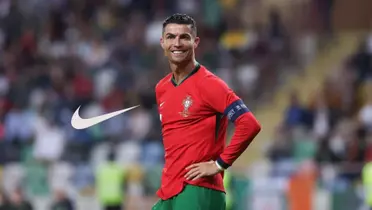 Cristiano Ronaldo smiles while wearing the Portugal jersey and the Nike logo is next to him.