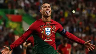 Cristiano Ronaldo sticks his tongue out while wearing the Portugal national team jersey; the Portugal national team logo is in the middle.