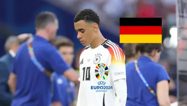 Jamal Musiala looks upset with the Germany national team jersey on as the EURO 2024 logo is on the shirt and the Germany flag is next to him. (Source: JilshieFCB X)