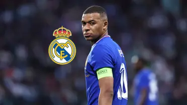 Kylian Mbappé looks back while wearing the French national team jersey and the Real Madrid badge is next to him.