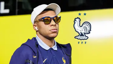 Kylian Mbappé looks serious while wearing sunglasses and the French national team badge is next to him. 