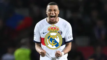 Kylian Mbappé screams with joy while wearing a white PSG jersey and the Real Madrid badge is in the middle.
