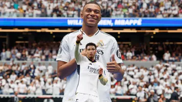 Kylian Mbappé smiles and points at the Real Madrid badge while Jude Bellingham points and holds the Real Madrid badge on his jersey. (Source: Real Madrid, Jude Bellingham X)