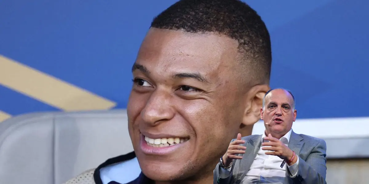 Kylian Mbappé smiles while sitting on the bench and Javier Tebas talks while having a microphone.