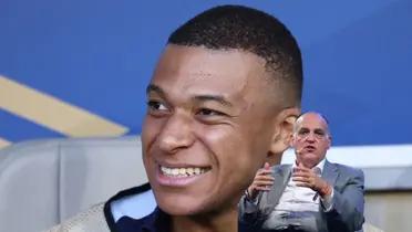 Kylian Mbappé smiles while sitting on the bench and Javier Tebas talks while having a microphone.