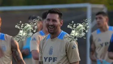 Lionel Messi laughs while wearing the Argentina training kit and flying money is around him.