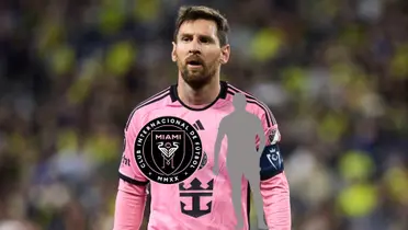 Lionel Messi looks to the crowd while wearing the Inter Miami jersey. The Inter Miami badge and a mystery player is below him.