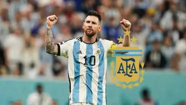 Lionel Messi puts his fists in the air while wearing the Argentina national team as the Argentina national team badge is next to him.