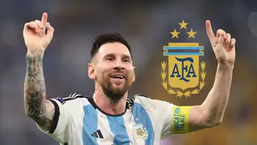 Lionel Messi smiles and points two fingers to the sky while wearing the Argentina national team jersey; the Argentina national team badge is next to him.