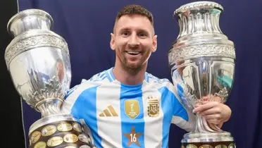 Lionel Messi smiles as he holds two Copa America trophies with the Argentina jersey on. (Source: Lionel Messi Instagram)