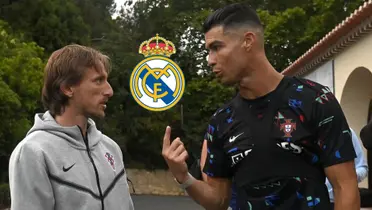 Luka Modric and Cristiano Ronaldo talk together while wearing their own national team gear and the Real Madrid badge is in between them.