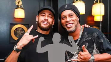 Neymar and Ronaldinho smiles as they pose for a picture together and a mystery player is in the middle.