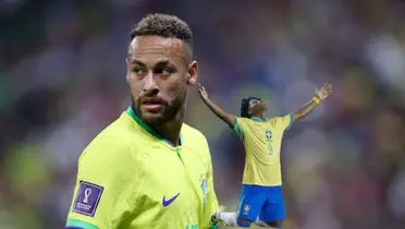 Neymar Jr. looks back while Endrick goes on down on his knees and puts his arm out; they both are wearing the Brazilian national team jerseys.