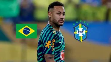 Neymar Jr. looks to the side while he is warming up; the Brazil flag and the Brazilian national team badge is next to him. (Source: REUTERS) 