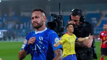 Neymar shows off his Al Hilal jersey while Cristiano Ronaldo celebrates with his arms out.