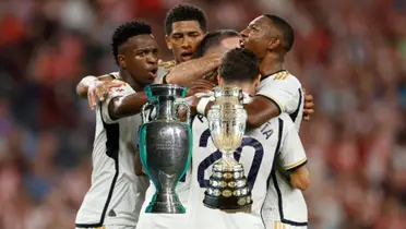 Real Madrid players celebrate together while the European Championship and the Copa America trophy are in front of them. (Source: INKL, UEFA, CONMEBOL)