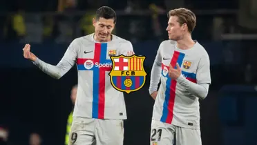 Robert Lewandowski and Frenkie De Jong discuss with one another while wearing FC Barcelona jerseys; the FC Barcelona badge is in the middle.