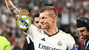 Toni Kroos smiles while wearing the Real Madrid jersey and the Real Madrid badge is next to him.