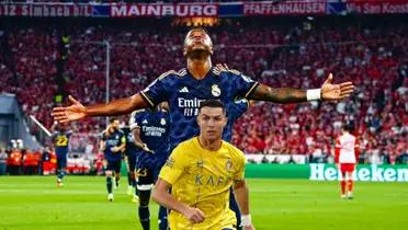 Vinicius Jr celebrates his goal fro Real Madrid with his arms out while Cristiano Ronaldo runs with Al Nassr.