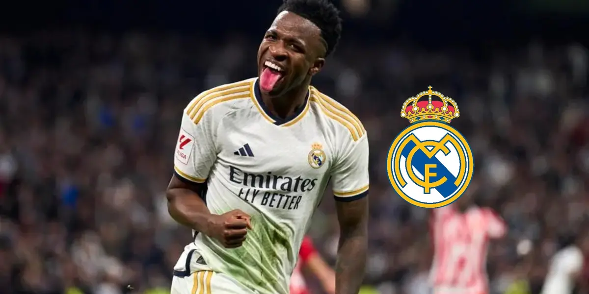 Vinicius Jr. sticks out his tongue while wearing the Real Madrid jersey and the logo of Real Madrid is next to him.