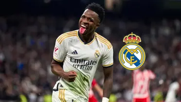 Vinicius Jr. sticks out his tongue while wearing the Real Madrid jersey and the logo of Real Madrid is next to him.