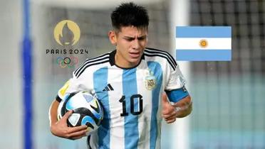 Claudio Echeverri holds the ball while playing for a youth Argentina national team as the Argentina flag and the Paris Olympics logo is next to him. (Source: Getty Images,