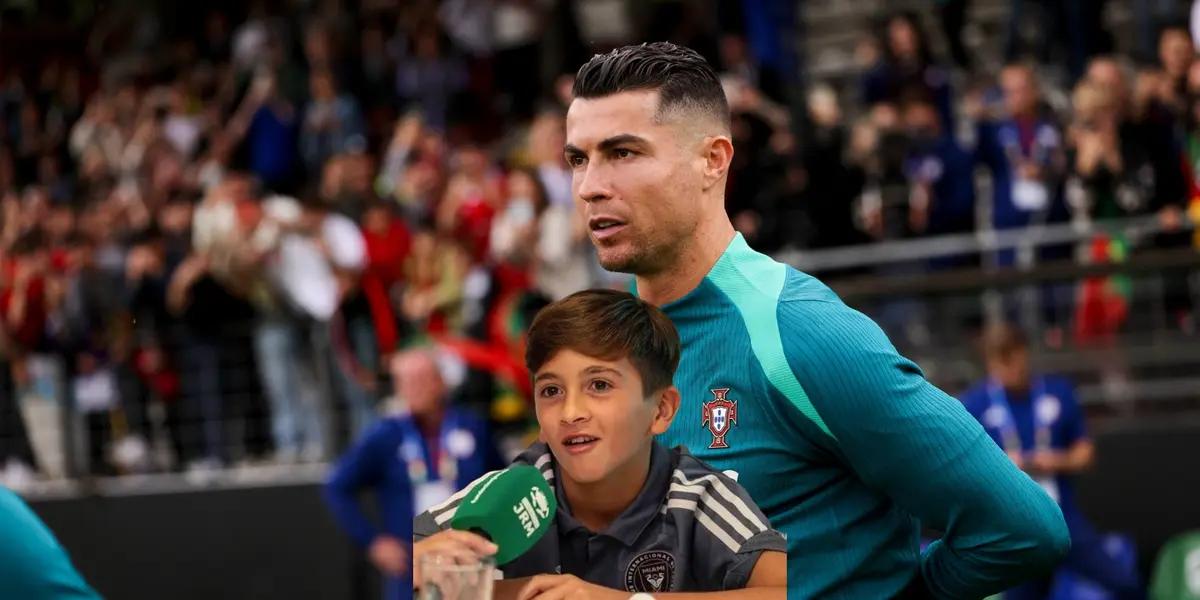 Cristiano Ronaldo looks at the pitch while wearing the Portugal training kit and Thiago Messi is speaking with a microphone.