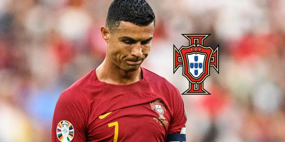 Cristiano Ronaldo looks upset while wearing the Portugal national team jersey and the Portugal national team badge is next to him.
