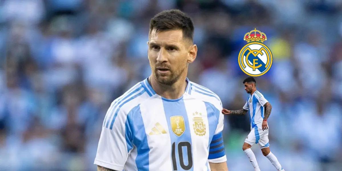 Lionel Messi stares while wearing the Argentina jersey and Cuti Romero runs with the Argentina jersey on, the Real Madrid badge is above him.