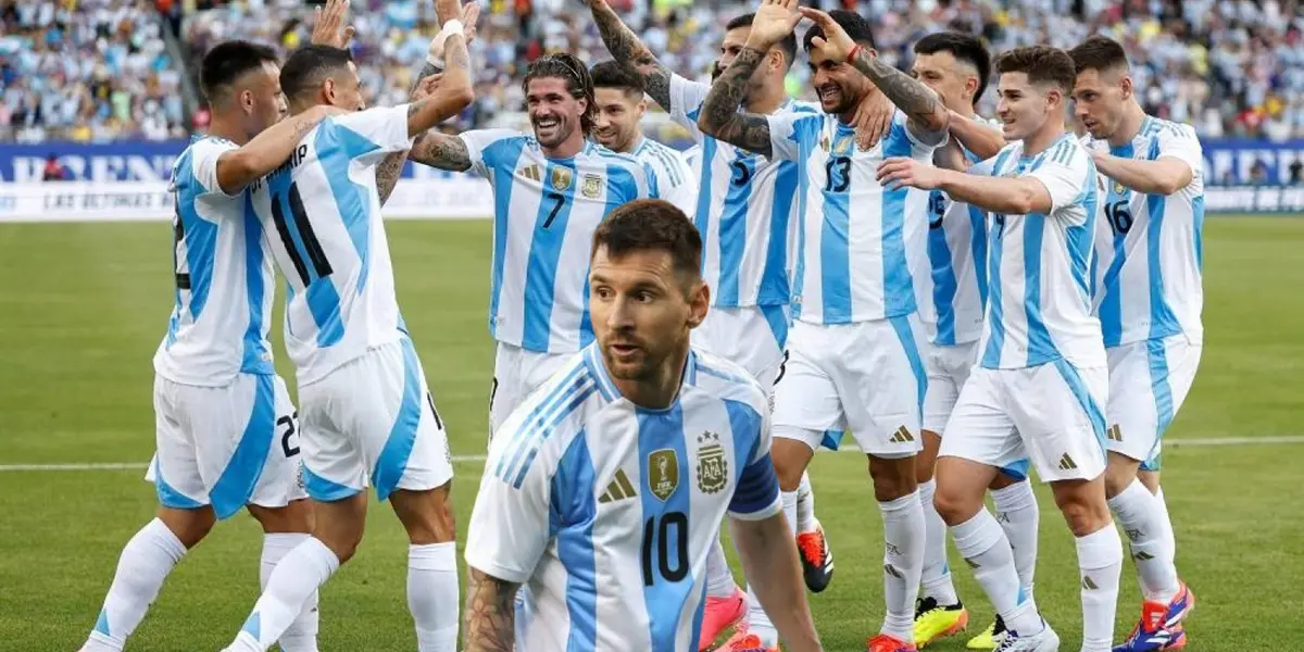 Lionel Messi looks to the side while wearing the Argentina jersey and the rest of the Argentina national team are celebrating together.