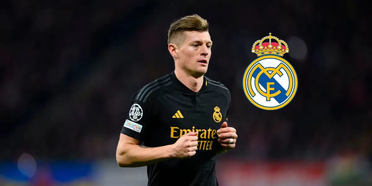 Toni Kroos jogs while wearing the black Real Madrid jersey and the Real Madrid crest is next to him.