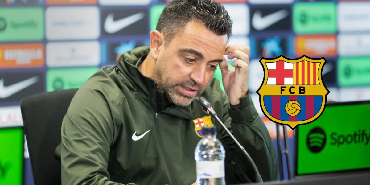 Xavi Hernandez scratches his head during a press conference while the FC Barcelona badge is next to him.